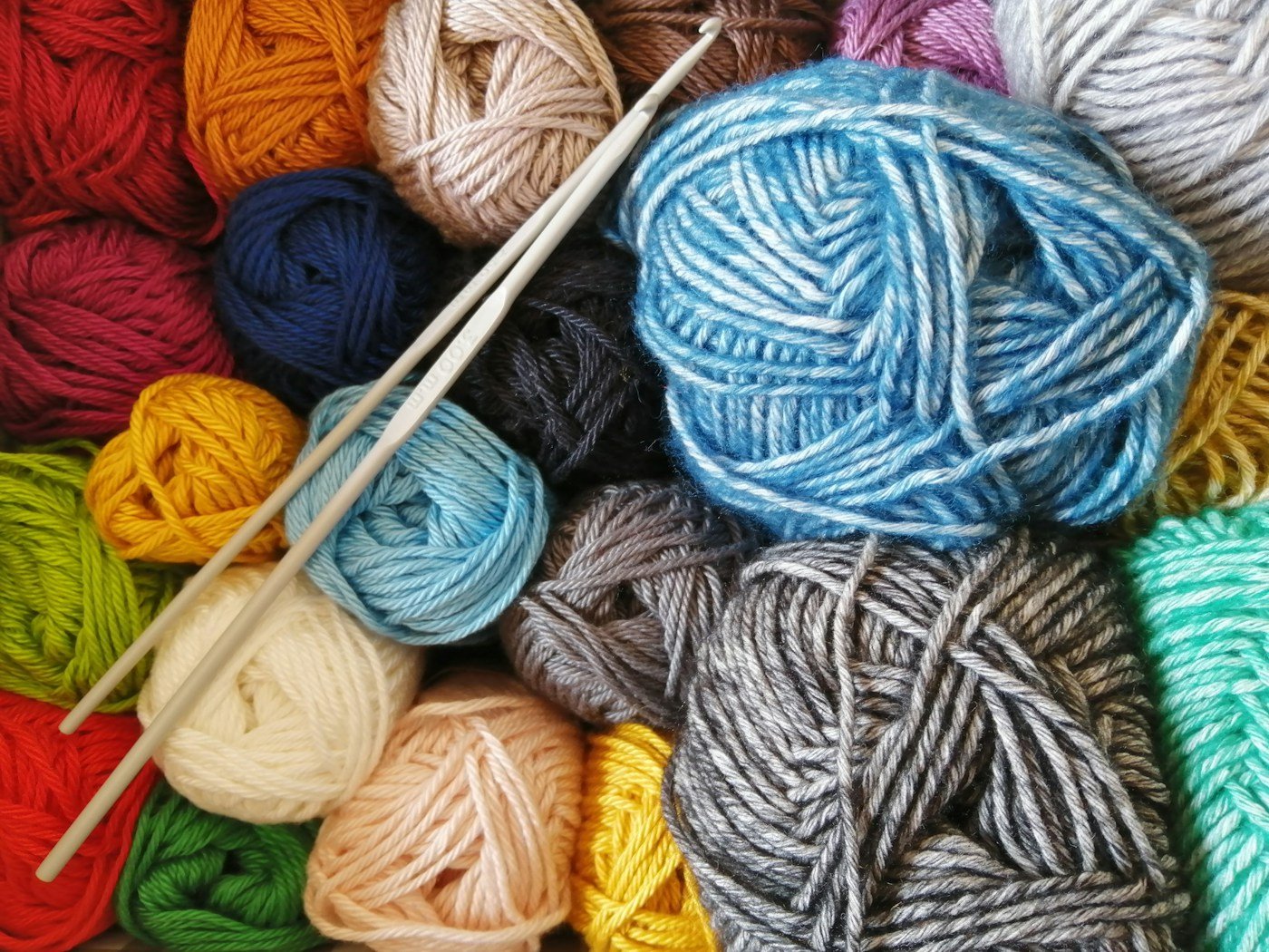 Colourful yarn skeins arranged with knitting needles